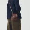 Borsa con linguetta semicircolare in pelle di Kate Sheridan Borsa con linguetta semicircolare in pelle di Kate Sheridan
